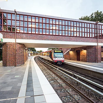 Eine Eisenbahnbrücke mit rotem Backstein und großen Fenstern.