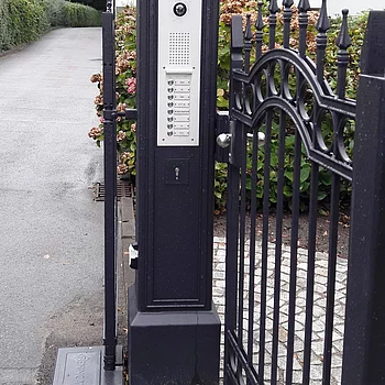 Schwarze, schmiedeeiserne Toranlage mit einem integrierten Gegensprechanlage-Panel und...