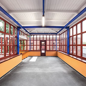 Metallbau Innenansicht eines modernen Stahlbaugebäudes mit großen Fenstern in Rot und einer...