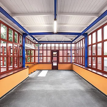 Metallbau Innenansicht eines modernen Stahlbaugebäudes mit großen Fenstern in Rot und einer...